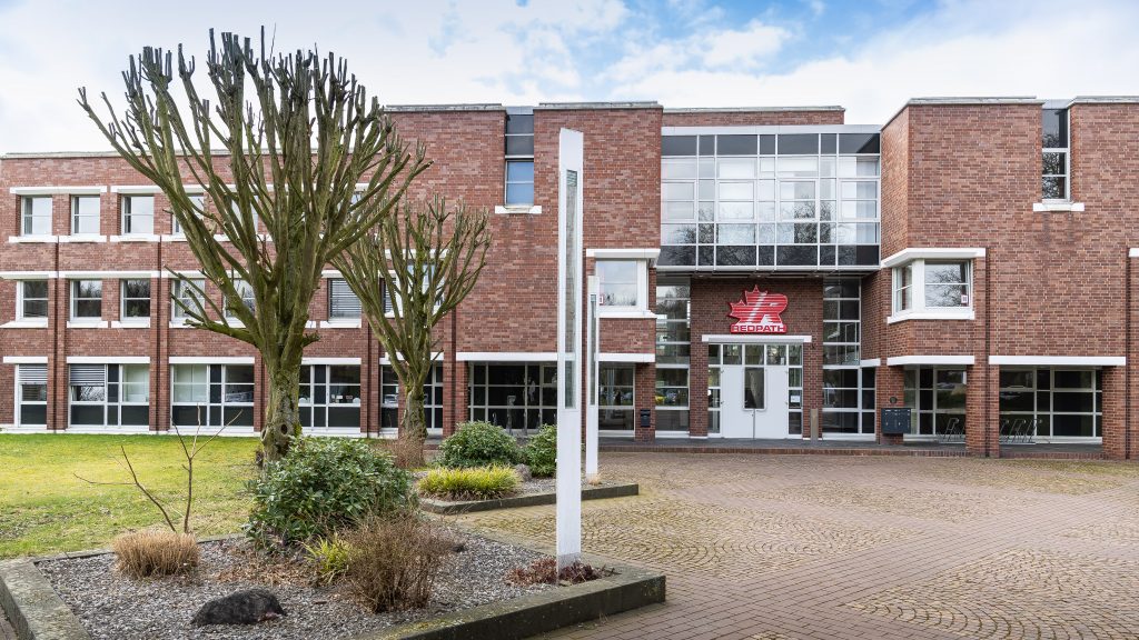Haupteingang mit Vorplatz und Bäumen im Frühling am Firmengelände von REDPATH DEILMANN in Dortmund Kurl